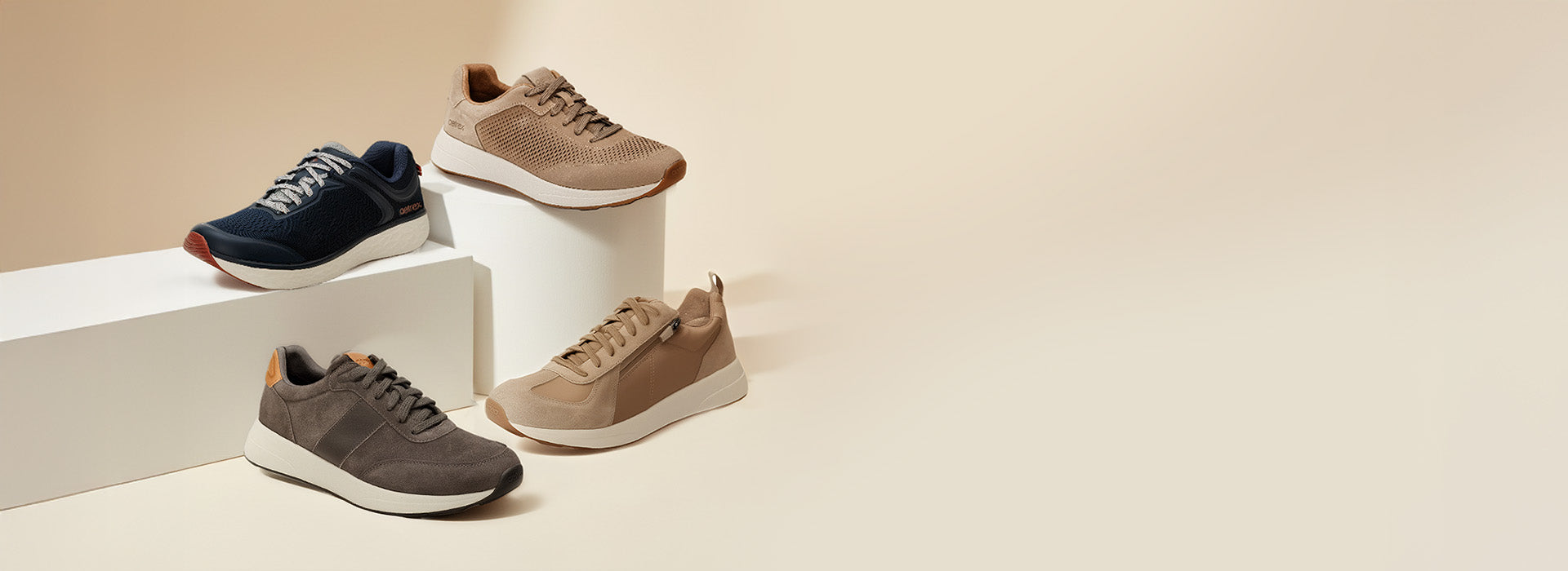 Four pairs of sneakers in navy, brown, and gray on a beige background