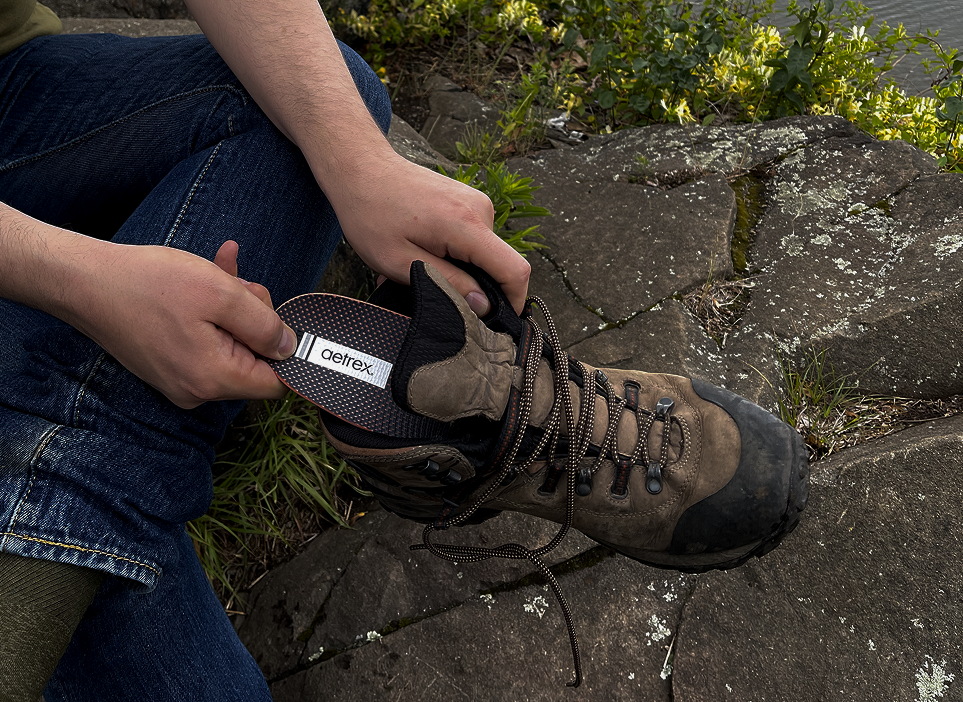 Person adjusting a hiking boot inserting an aetrex orthotic