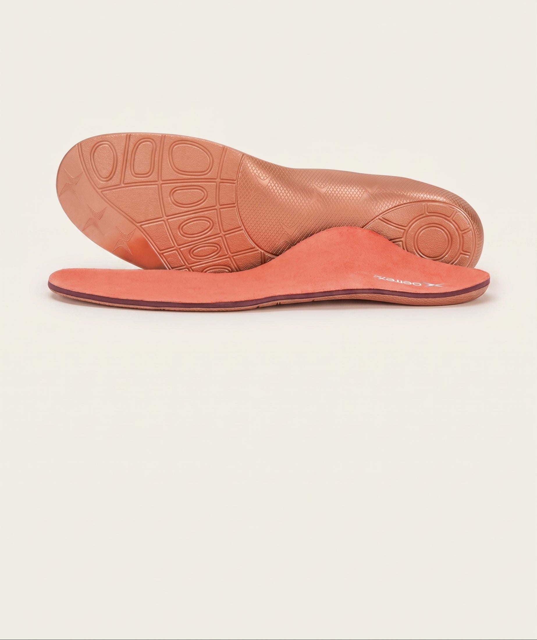 Pair of pink insoles on a beige background