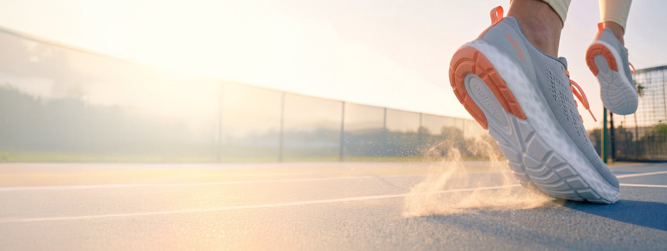Person wearing blue running shoes on a track with a blurred background