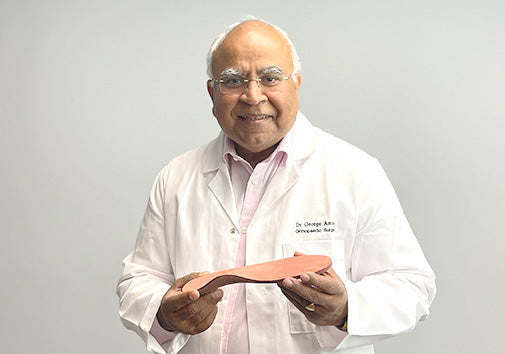 Dr. George holding an orthotic