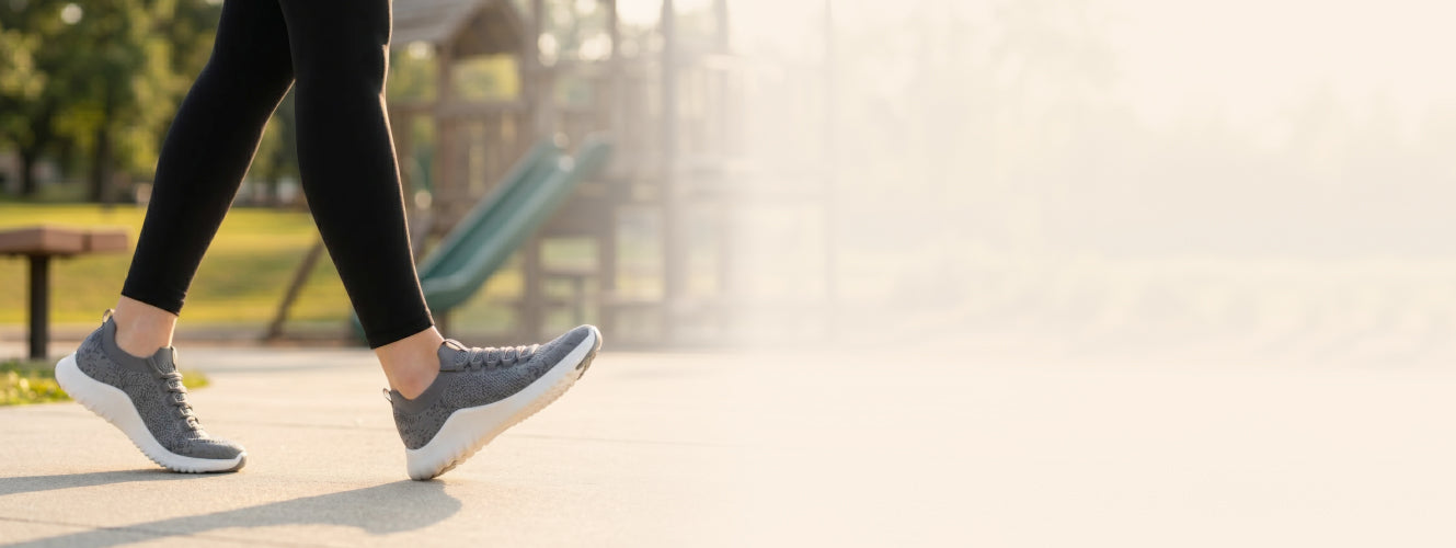 Person walking on a path with a playground in the background