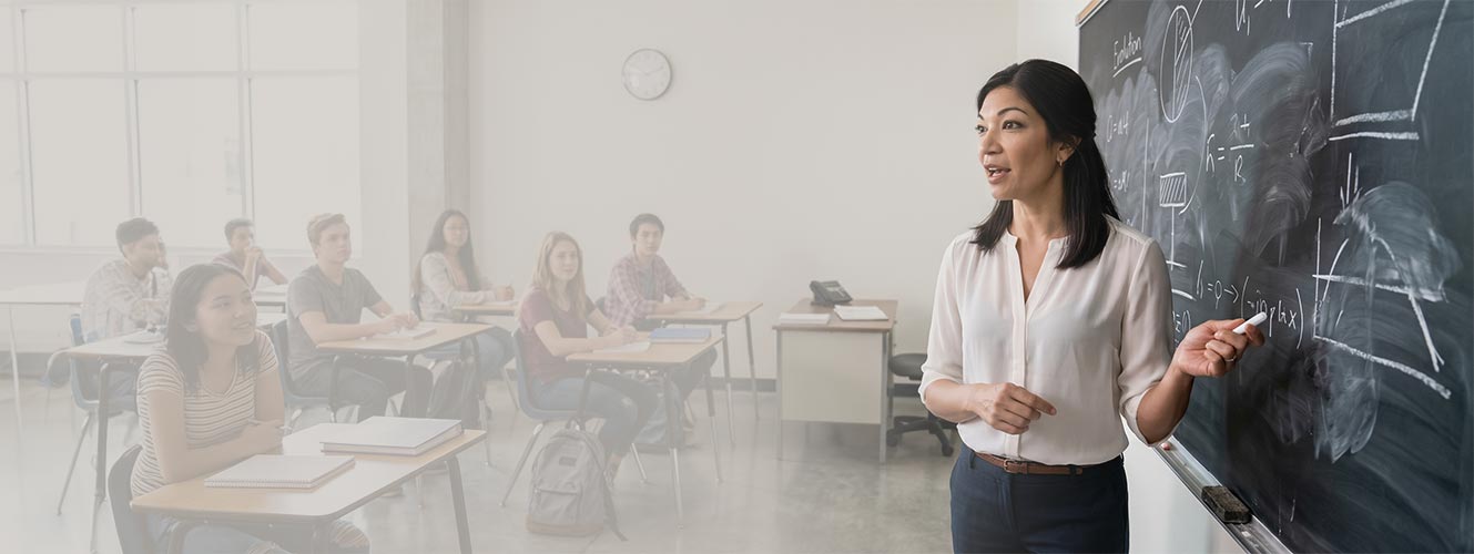 Teacher at a blackboard with students in a classroom setting