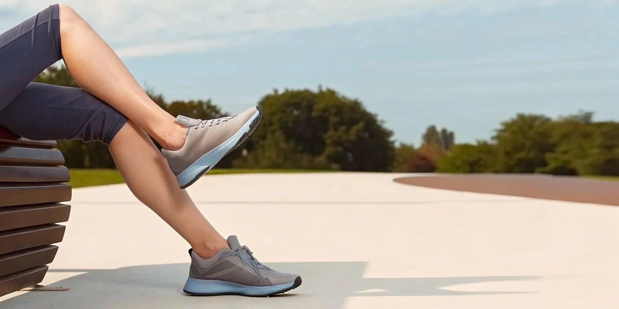 Runner resting on a bench, wearing shoes with the best insoles for high arches running.