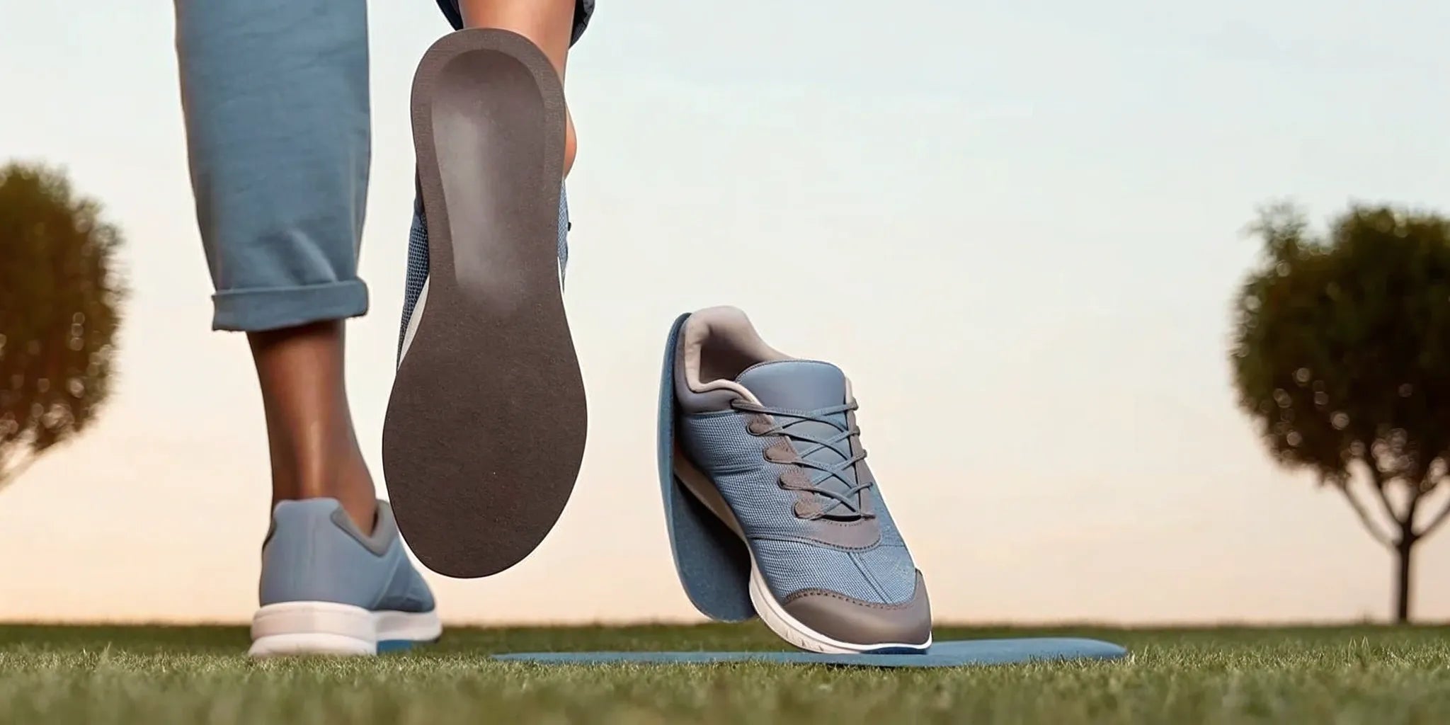 High arch support running insoles placed next to a pair of blue running shoes.