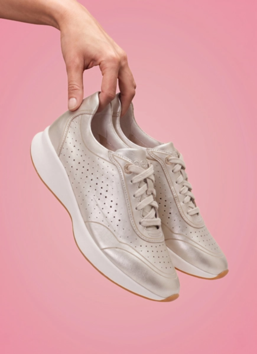 white gold serena arch support sneakers on a pink background