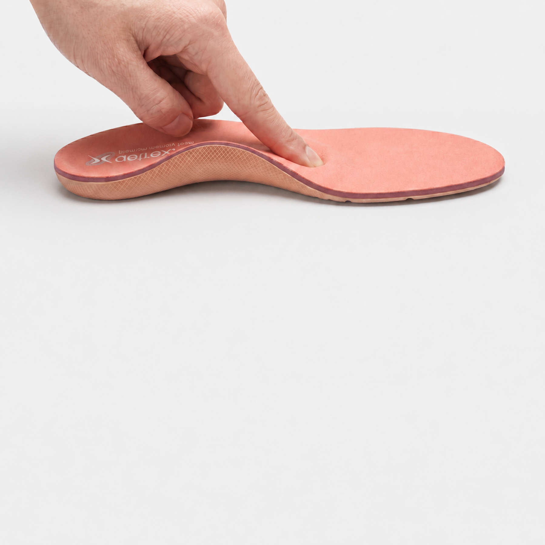 finger touching orthotic to show cushioning 