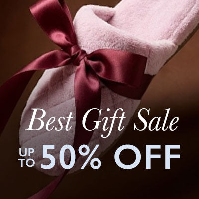 Pink slippers with a red bow and 'Best Gift Sale Up to 50% Off' text on a dark background