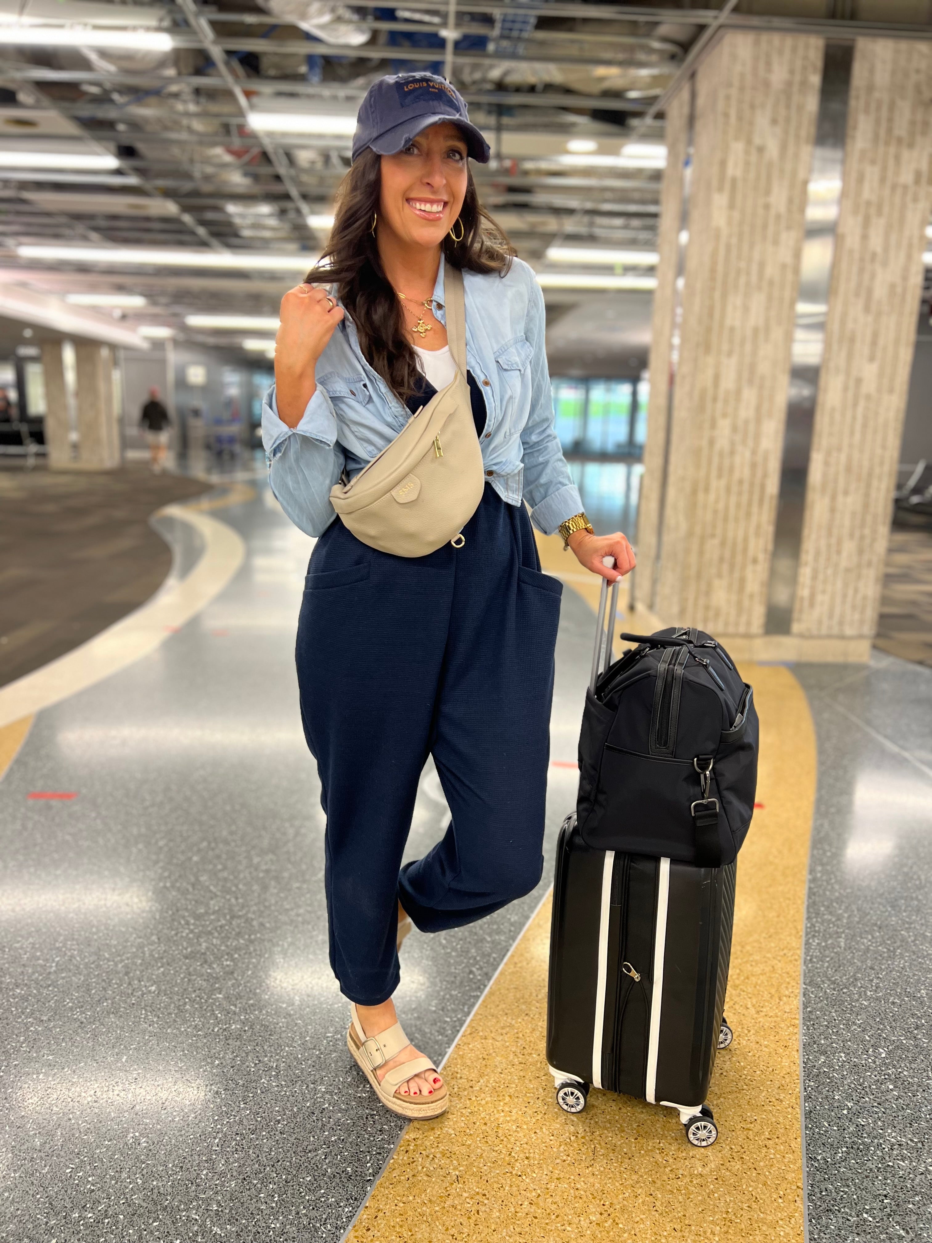 Woman in an airport with a suitcase and handbag