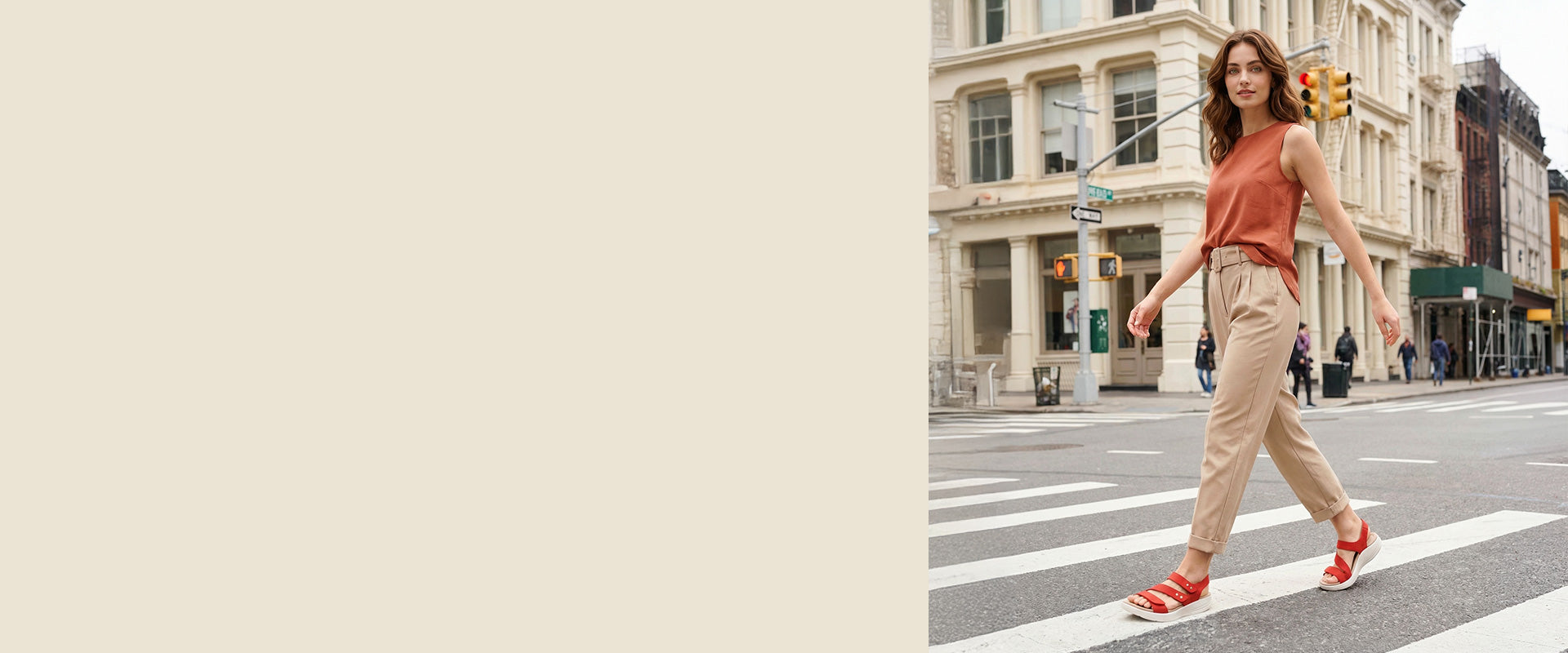 Woman crossing a city street with buildings and pedestrians in the background