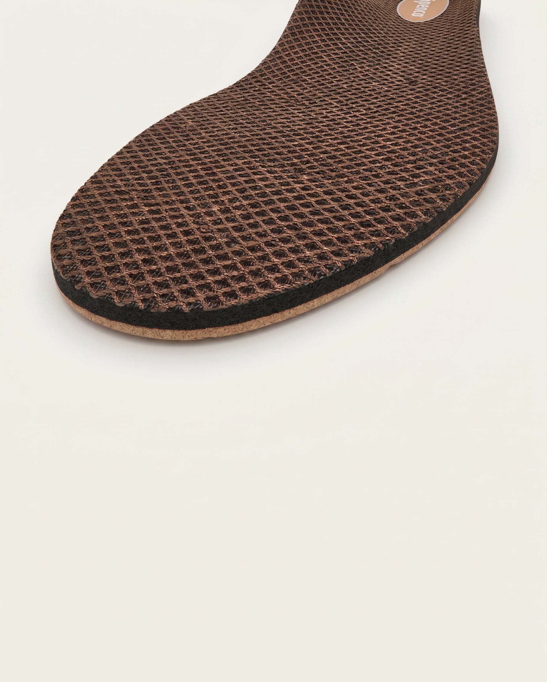 Brown shoe insole with textured surface on a light gray background