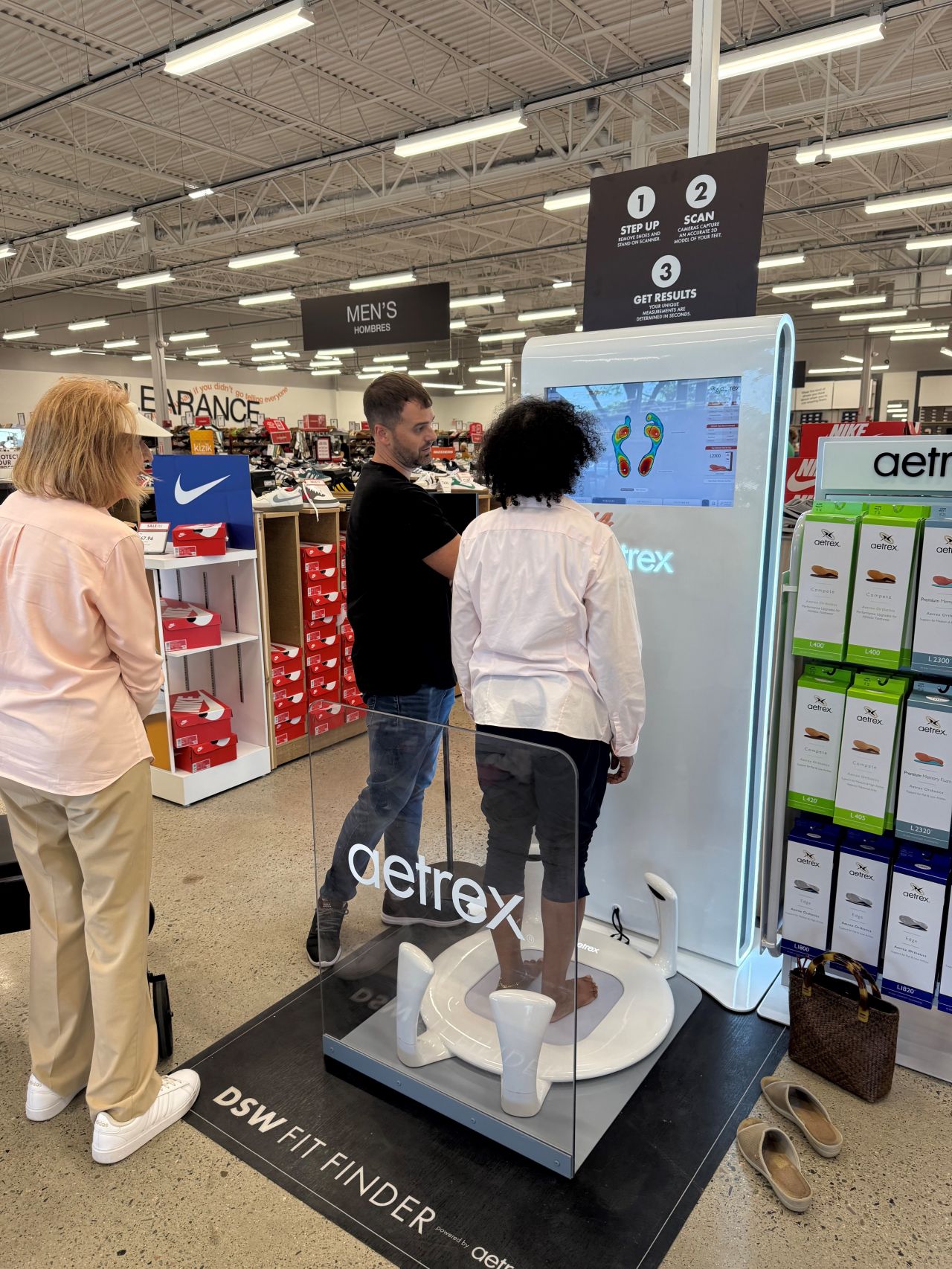 People using a Aetrex shoe fitting machine in a store