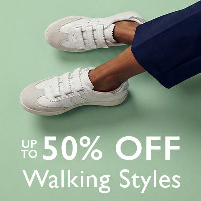 White sneakers worn by a person on a light green background with promotional text.